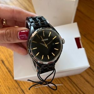 Brand new in box NIXON MINX BLACK / GOLD watch. The box shows signs of wear.